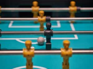 Foosball table with the ball in front of the only black piece