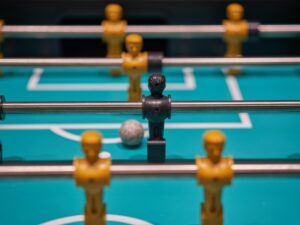 Foosball table with the ball in front of the only black piece